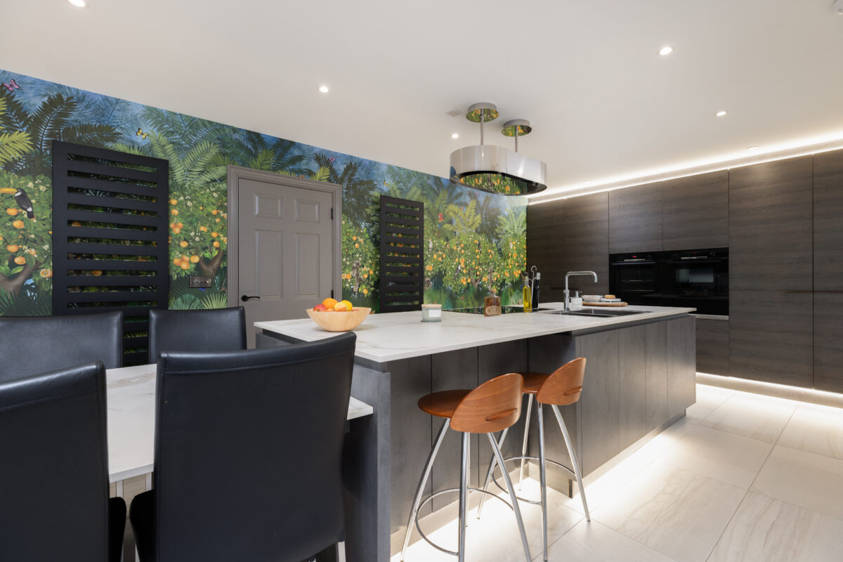 Spacious kitchen renovation with a central island and an artistic wall mural and fitted integrated cabinetry, enhancing the room's contemporary design.
