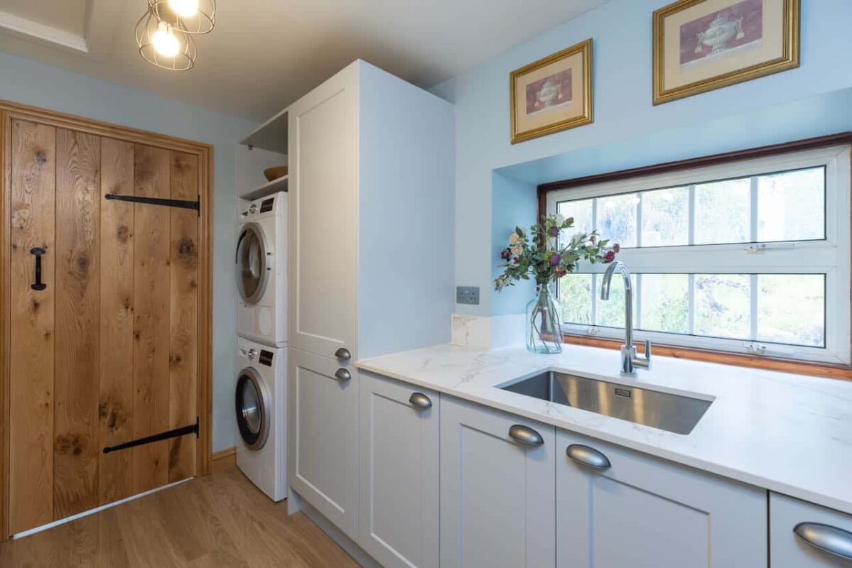 Utility room featuring ample white cabinetry, complete with a washer and dryer.