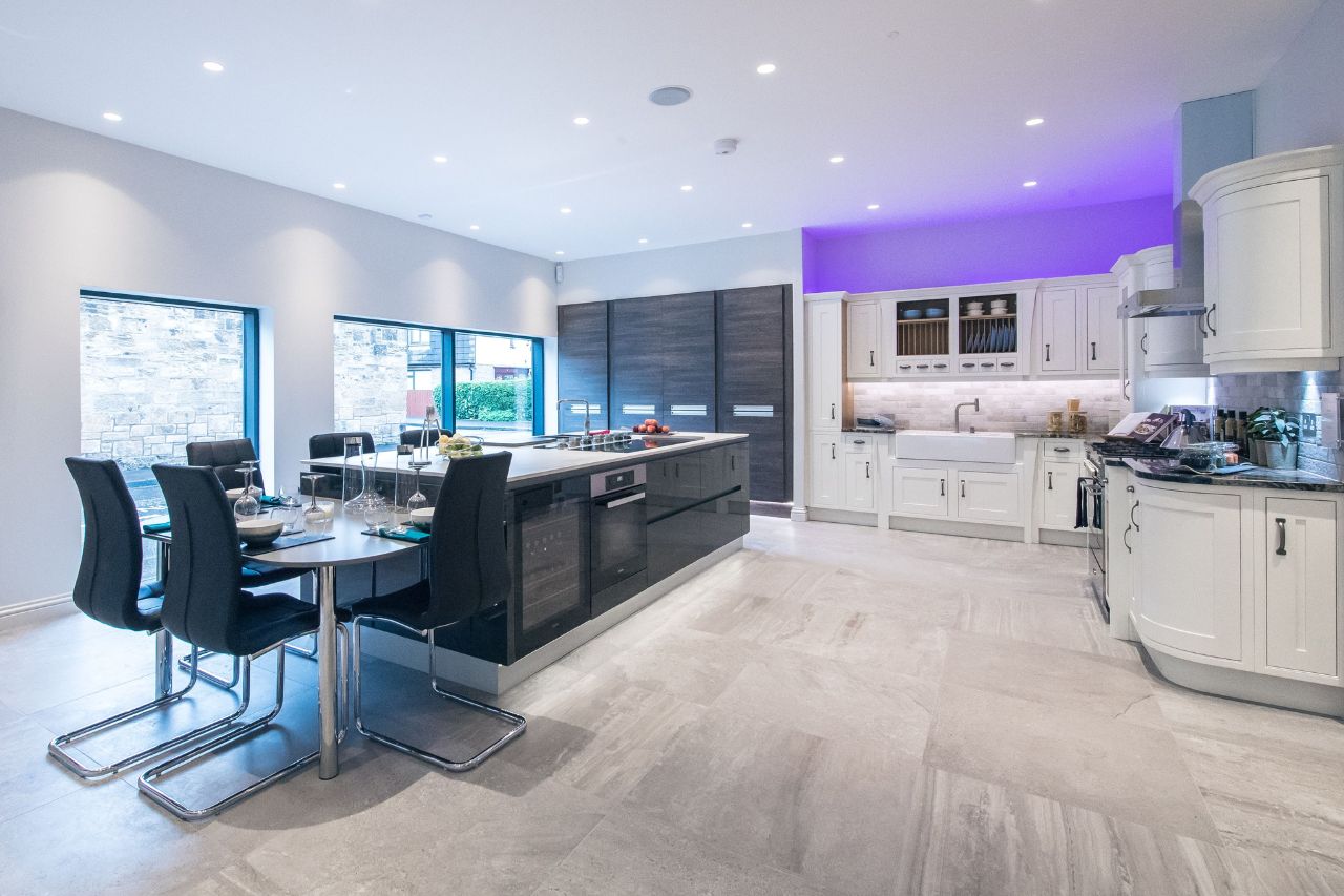 A large kitchen studio in our Edinburgh showroom featuring a traditional shaker door cabinetry in a cream finish. The space also features a large kitchen island with several compartments.