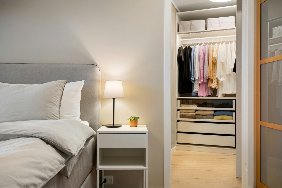 A modern bedroom renovation with the bedroom area and a large fitted wardrobe.