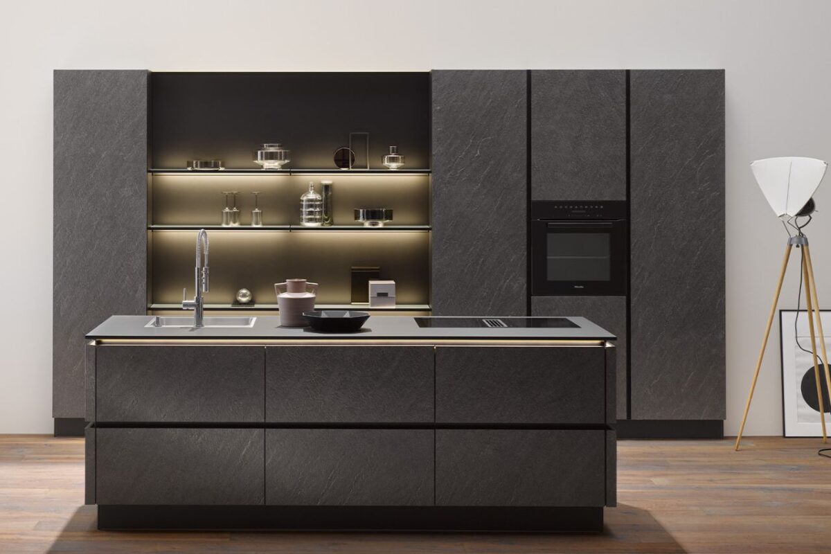 A sleek modern kitchen featuring handleless cabinetry from Hacker and an island with a built-in sink, highlighting clean lines and contemporary design.