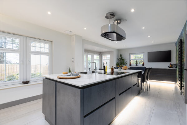 Modern kitchen renovation featuring a large island, a dining area, and a wallpaper mural as a striking focal point.