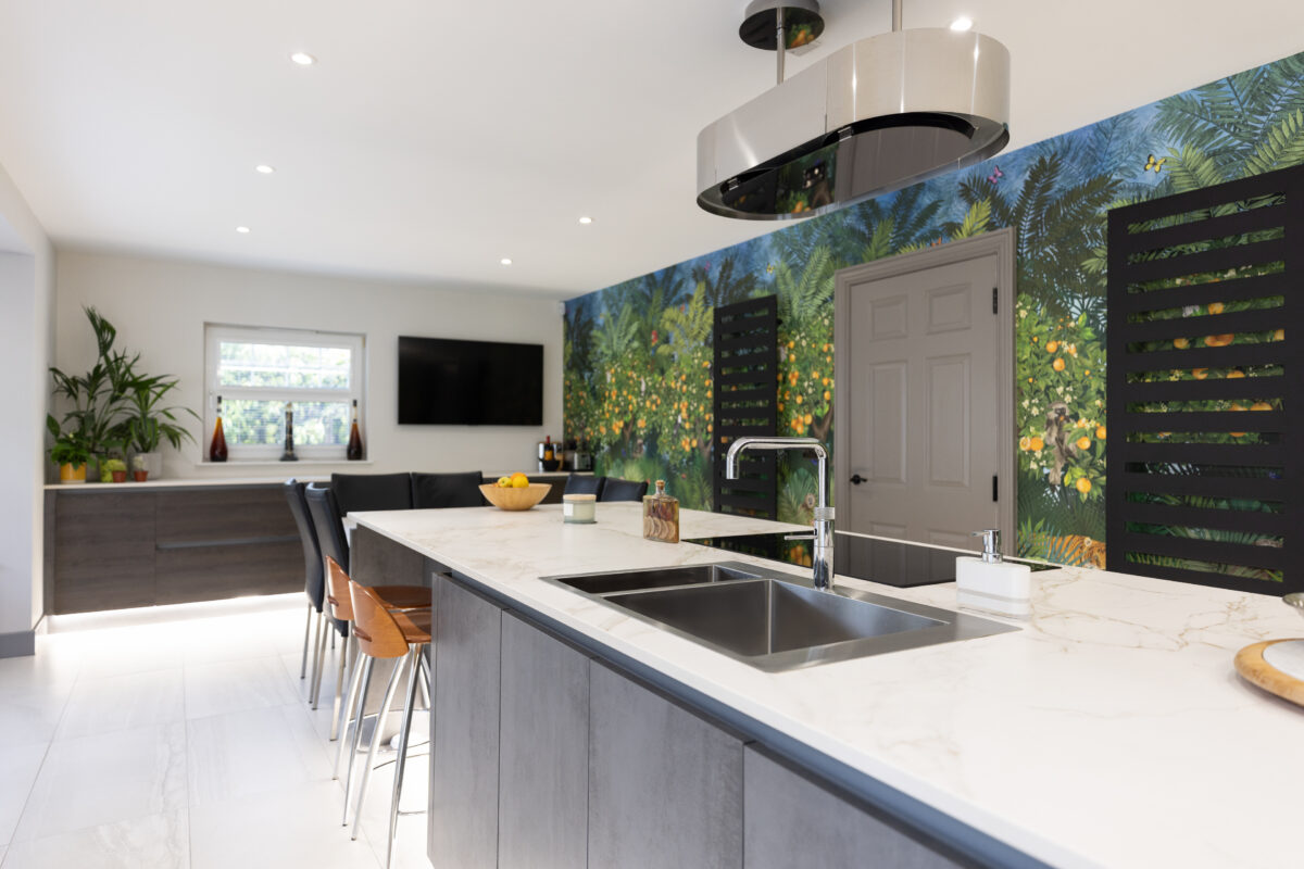 Modern kitchen renovation featuring a large island, a dining area, and a wallpaper mural as a striking focal point.