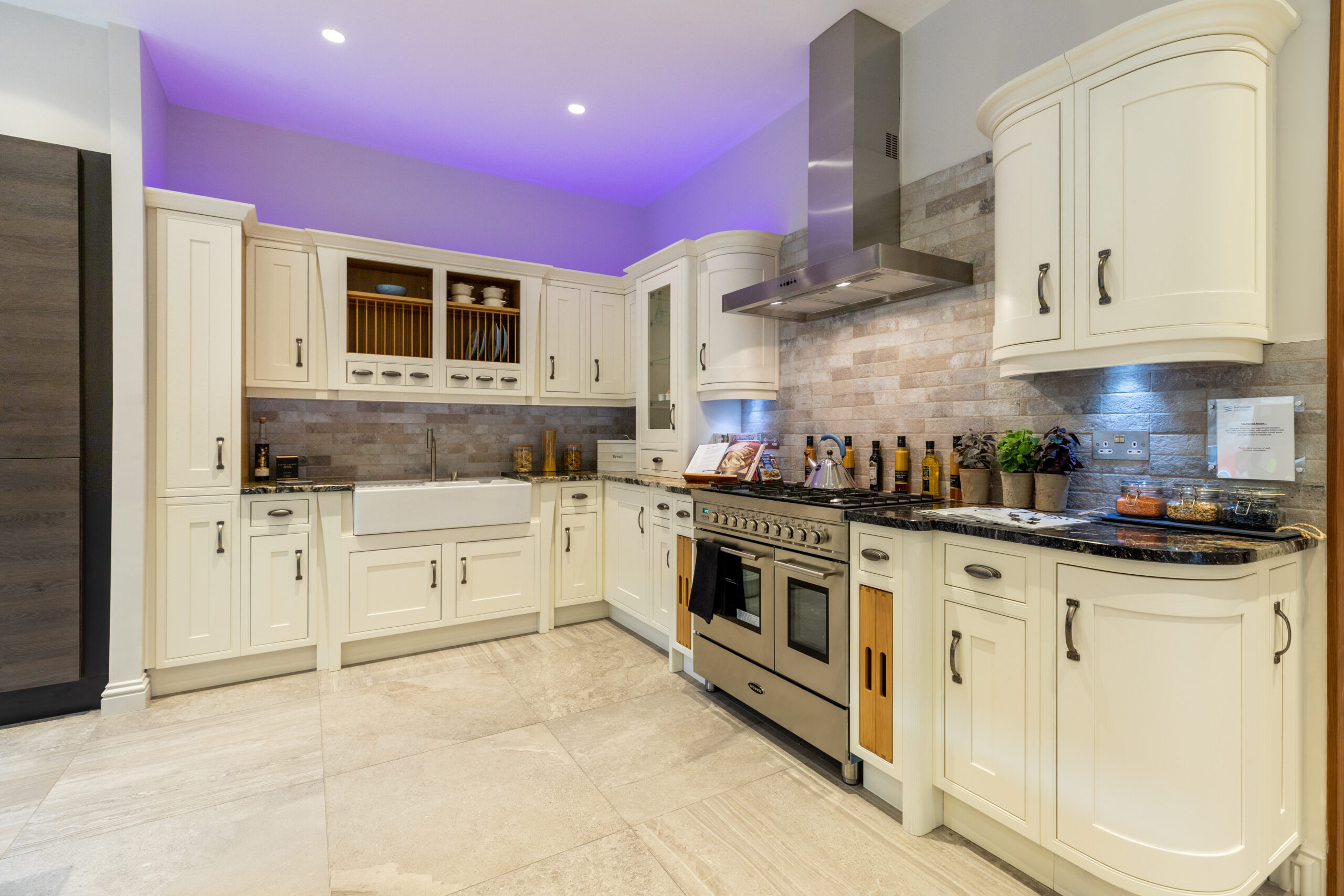 A shaker-style traditional kitchen in cream, finished in our kitchen showroom in Edinburgh. This includes bespoke cabinetry with ample storage and a cooker hood.