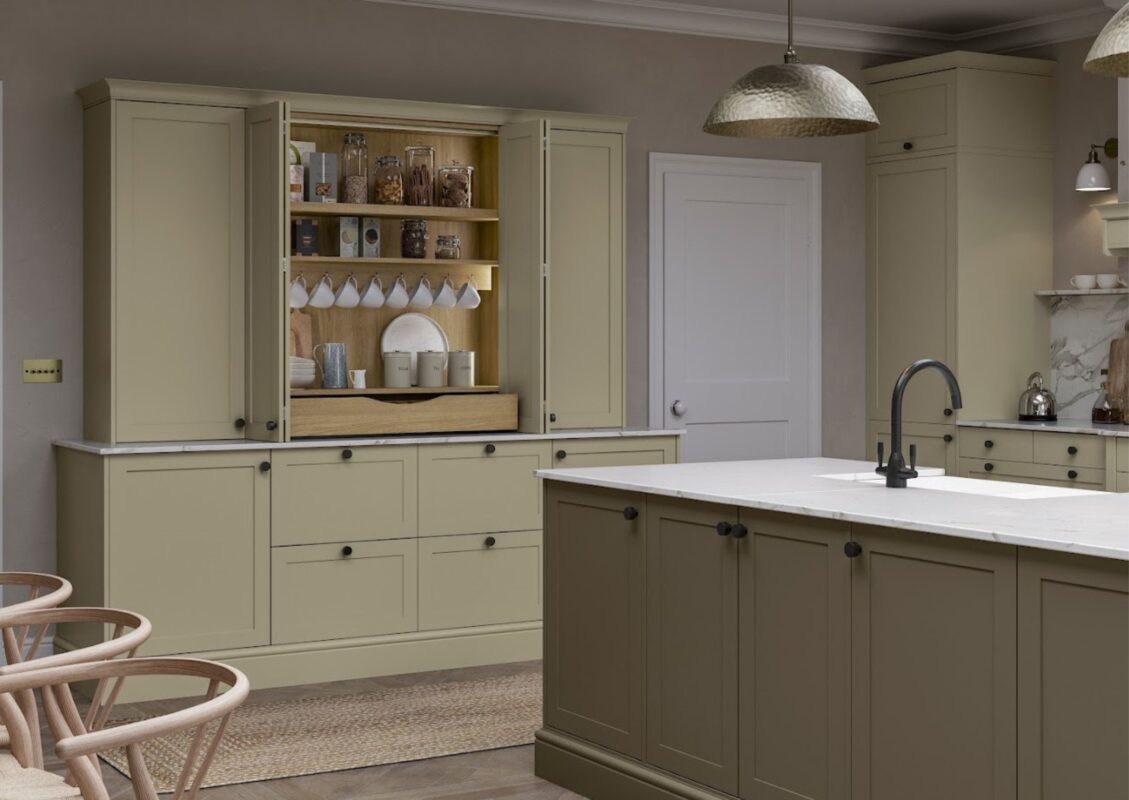 A spacious kitchen featuring base and wall units in a light yellow finish with ample storage, complemented by a kitchen island with an integrated sink.